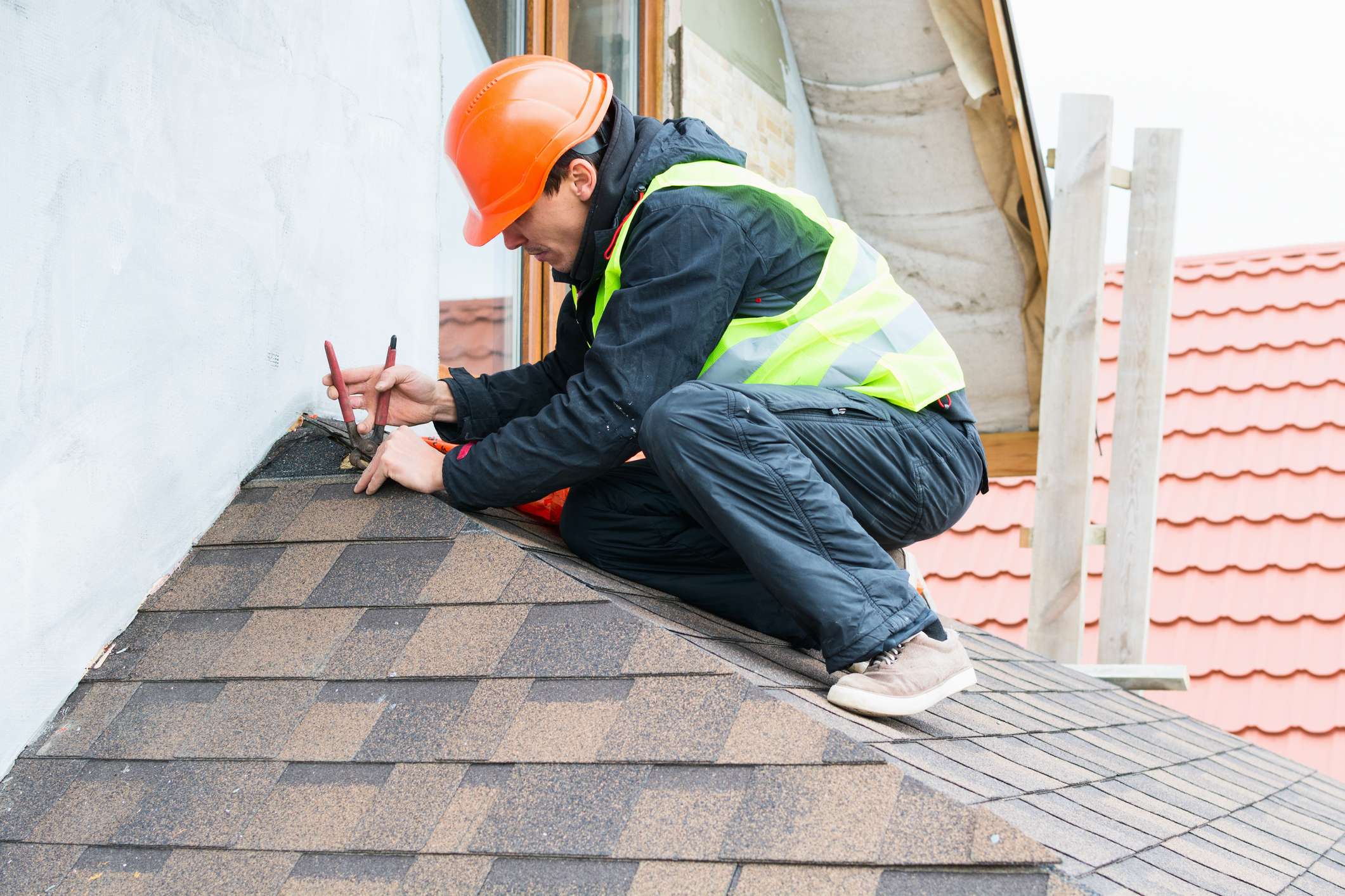 Roofing worker repairing a damaged roof